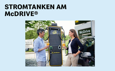 Zwei Personen stehen an einer Strom-Tankstelle von EWE bei McDonald's