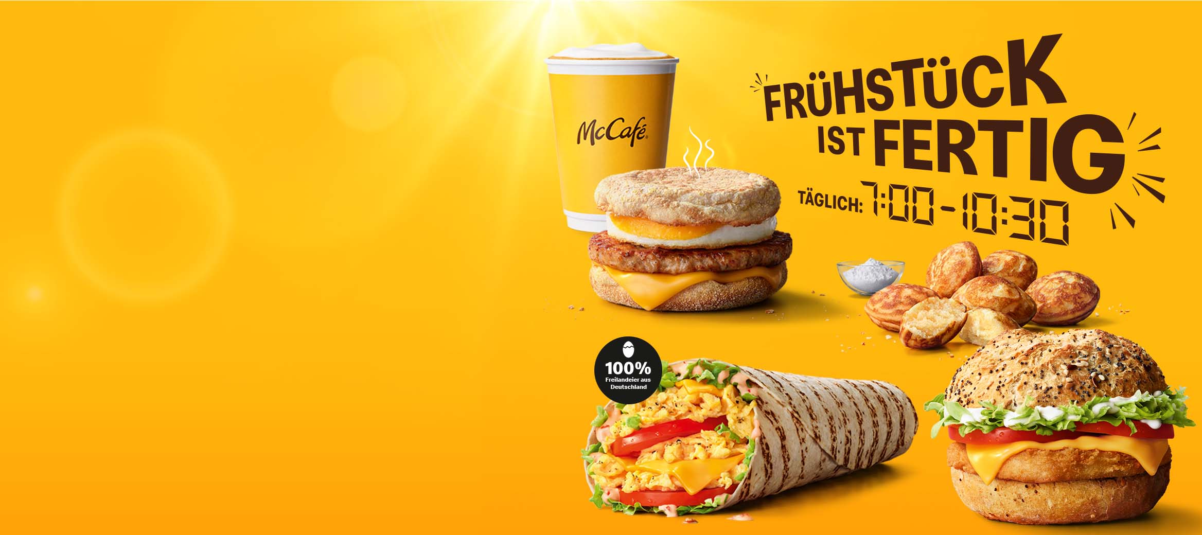 Das Bild zeigt die Überschrift „Frühstück ist fertig! Täglich von 7:00 bis 10:30 Uhr". Daneben sehen wir einen Becher Kaffee, einen McMuffin® Bacon & Egg, Mini Pancakes, einen McWrap® Rührei Cheese und einen Big Morning Chicken