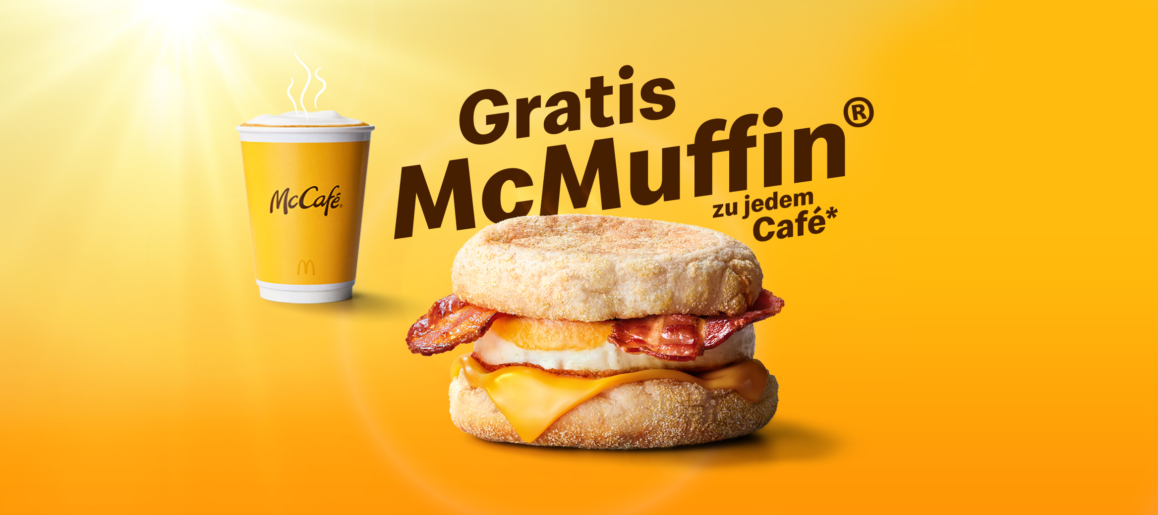Das Bild zeigt die Überschrift „Gratis McMuffin zu jedem Café". Daneben steht ein Becher Kaffee, ein McMuffin Bacon & Egg.