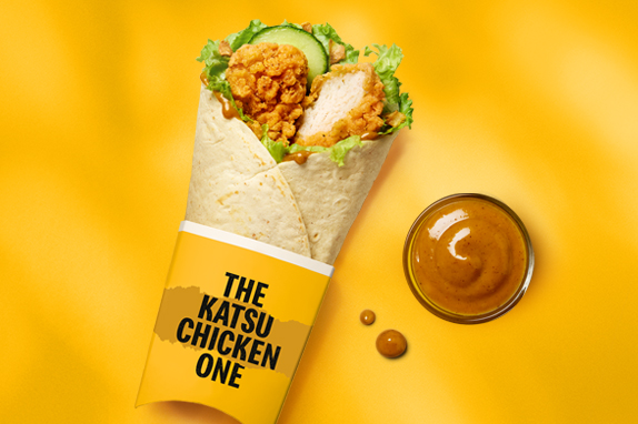 The Katsu Chicken wrap on a yellow background with bold black text that reads Big Flavour Wrapped